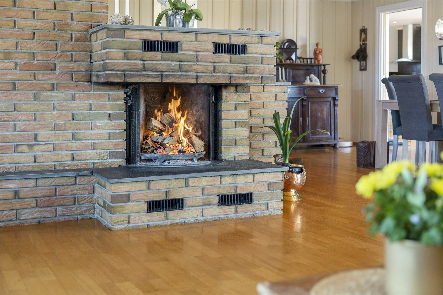 Den murte peisen er et solid og sentralt element i stuen, og gir god varme på kalde dager.