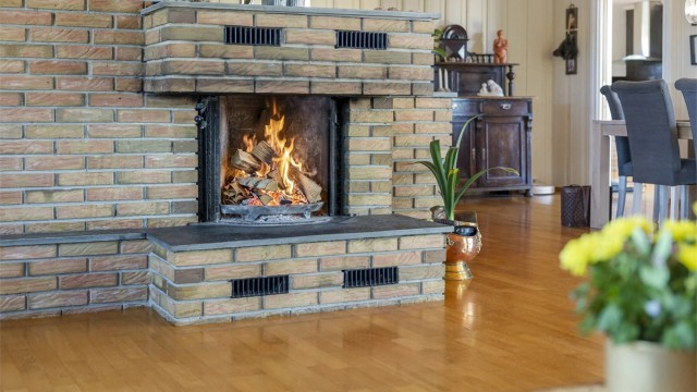 Den murte peisen er et solid og sentralt element i stuen, og gir god varme på kalde dager.