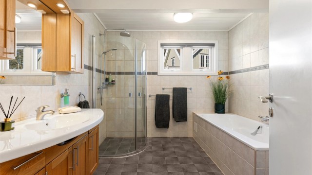 Stilrent bad i 2. etasje fra 2005, med både innebygget badekar og dusjhjørne.