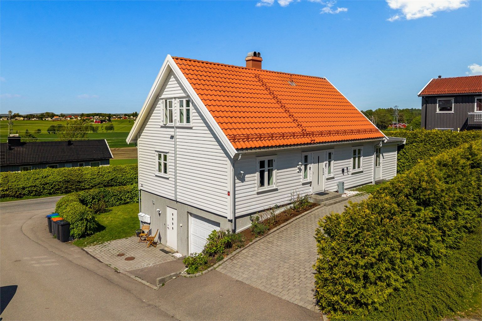 Eiendommen har integrert garasje og en pent opparbeidet, steinbelagt gårdsplass. [ Foto: Kron Media, Karl Filip Kronstad ]