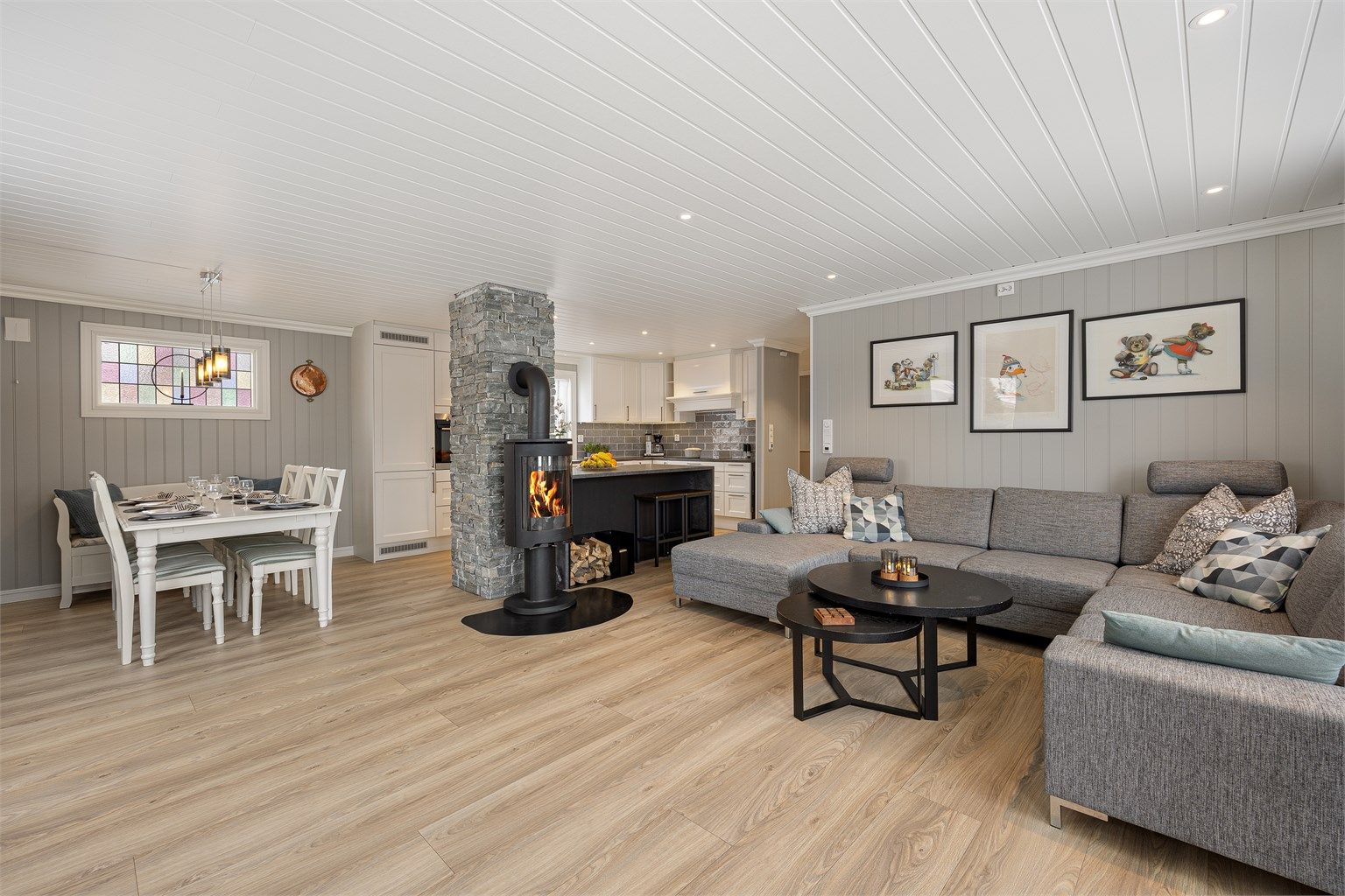 Den åpne løsningen mellom stue og kjøkken skaper en sosial og luftig atmosfære.