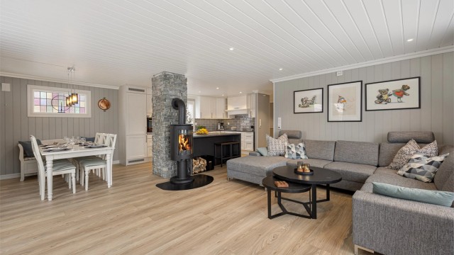 Den åpne løsningen mellom stue og kjøkken skaper en sosial og luftig atmosfære.