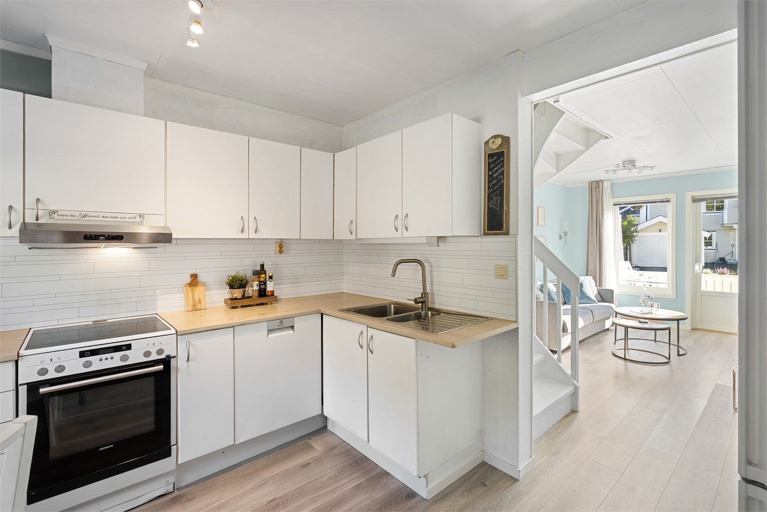 Kjøkkenet er utstyrt med komfyr med platetopp, ventilator i overskap, oppvaskmaskin under benkeplate og kjøleskap med fryserdel i nisje