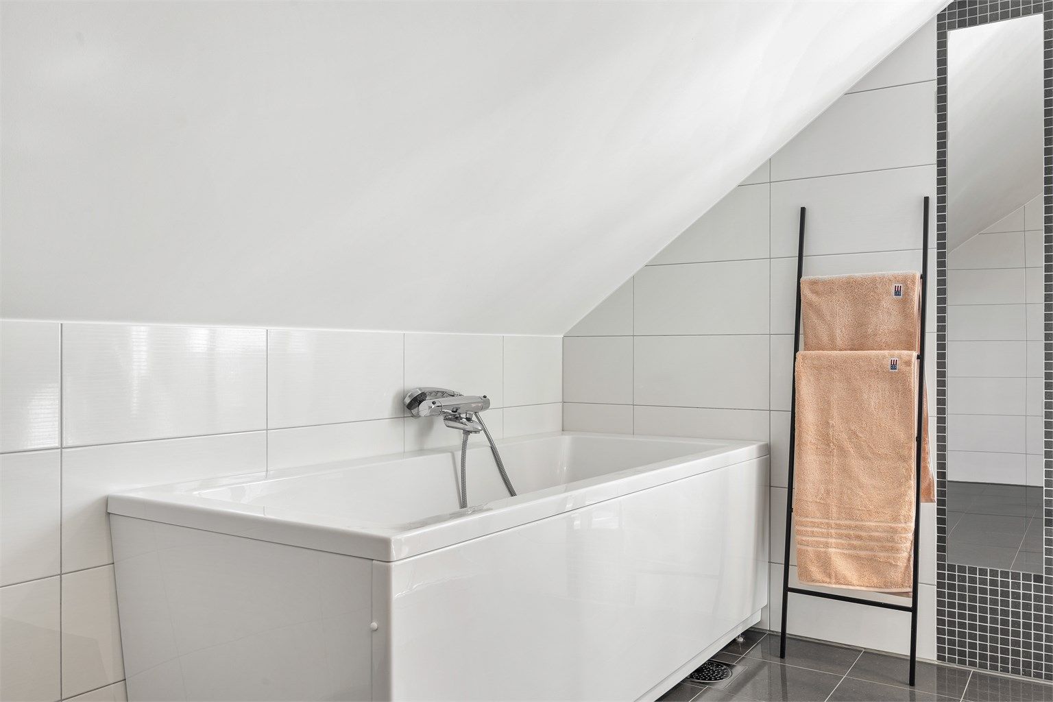 Badet er utstyrt med frittstående badekar med vegghengt armatur.