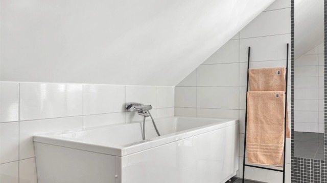 Badet er utstyrt med frittstående badekar med vegghengt armatur.