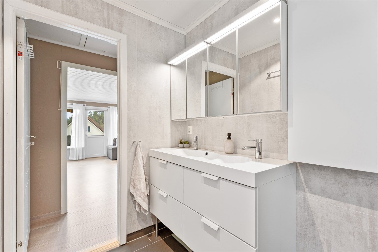 Det er dobbelt servant med god oppbevaringsplass samt tilhørende overskap med belysning. 