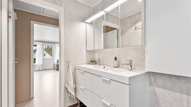 Det er dobbelt servant med god oppbevaringsplass samt tilhørende overskap med belysning.