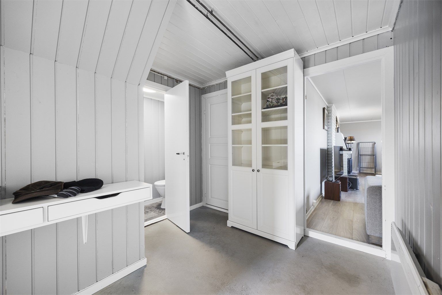 Fra gangen er det inngang til toalettrom og videre til det innredede oppholdsrommet.