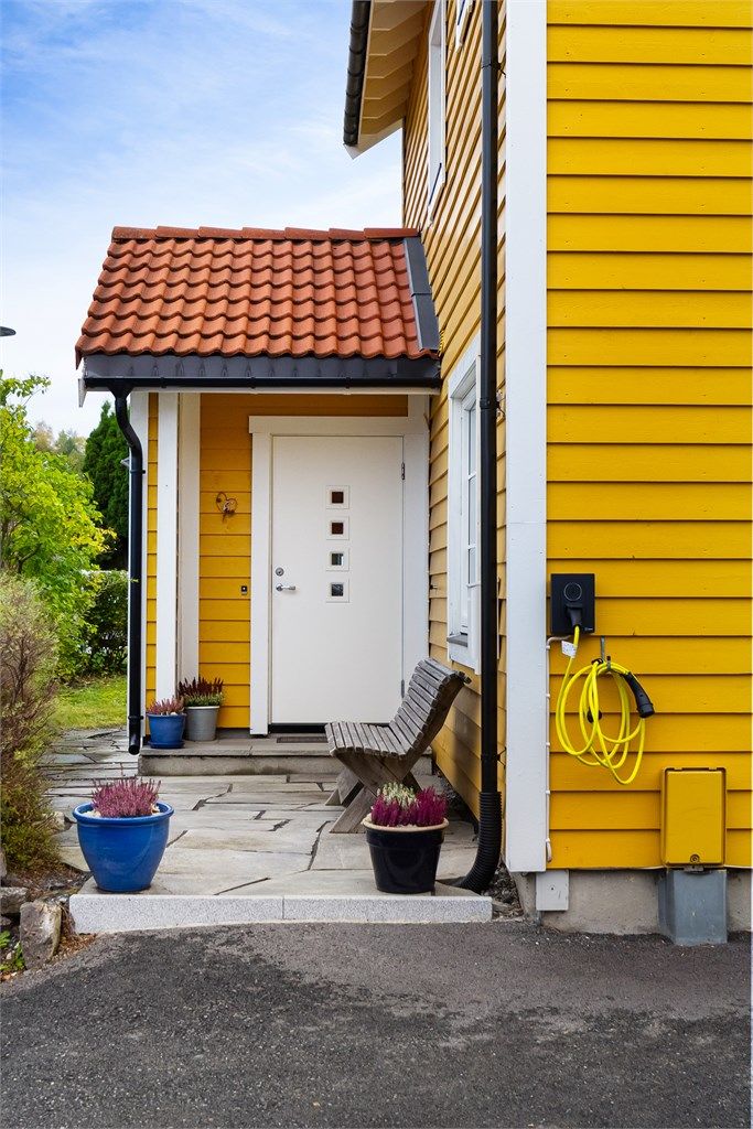 Velkommen inn. Det er montert elbillader på ytterveggen.