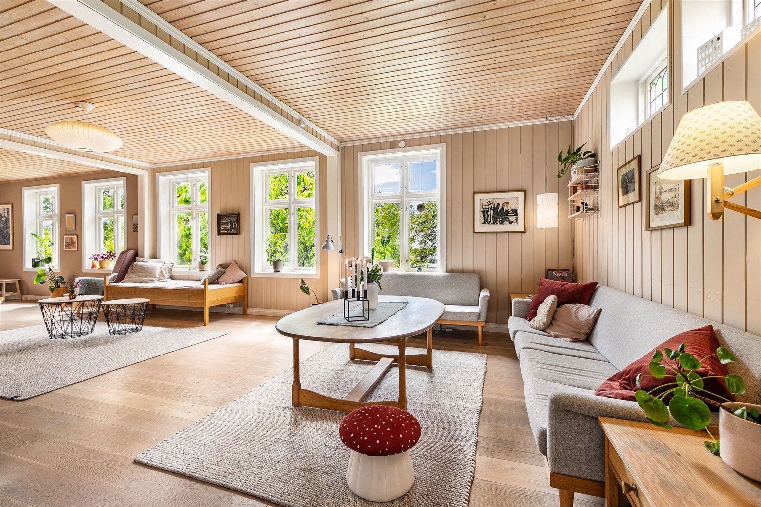 Høyreiste krysspostvinduer i både sør- og vestveggen fyller stuen med mye naturlig lys.