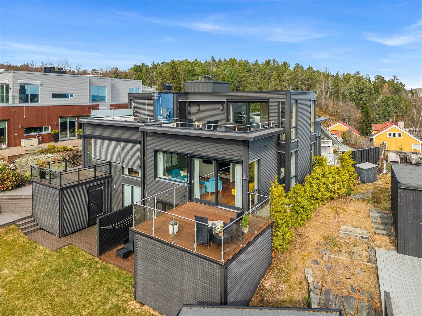 Fra luften ser man tydelig hvordan boligen ligger flott til med flere uteplasser, gode solforhold og nærhet til både natur og bebyggelse.