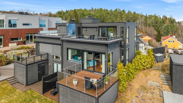Fra luften ser man tydelig hvordan boligen ligger flott til med flere uteplasser, gode solforhold og nærhet til både natur og bebyggelse.