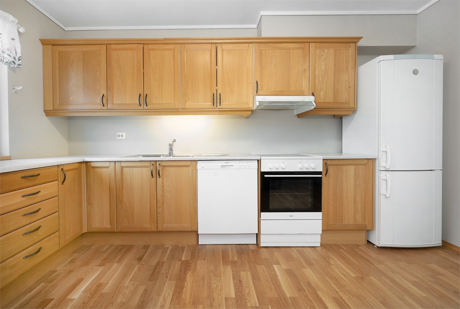 Kjøkkeninnredningen har profilerte fronter og en slitesterk benkeplate i laminat.