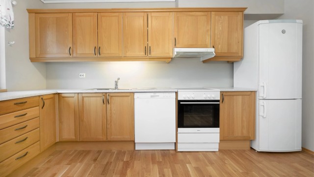 Kjøkkeninnredningen har profilerte fronter og en slitesterk benkeplate i laminat.