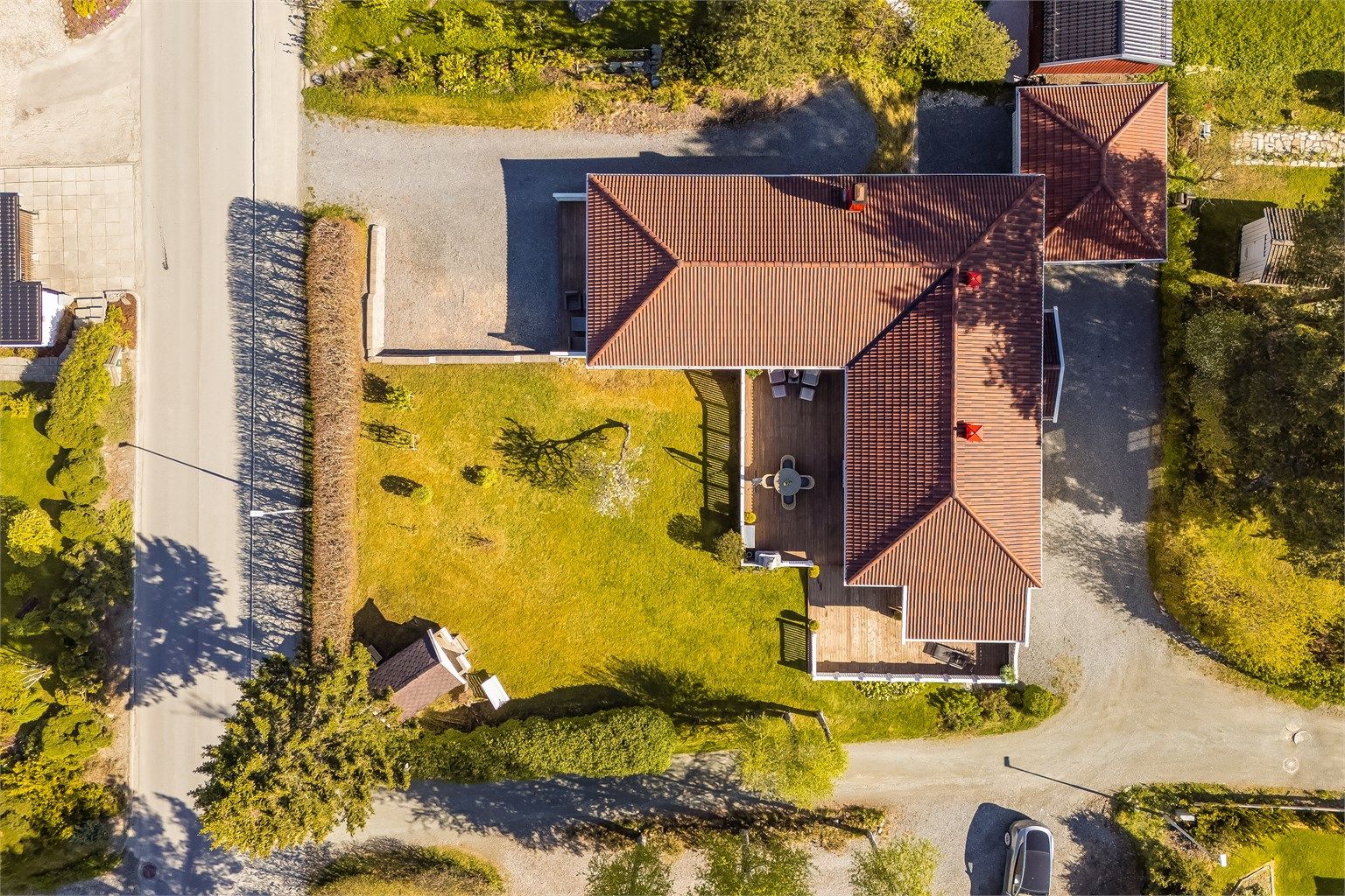 Tomten er festet, og er på hele 1 254 m2. Meget pent opparbeidet med plen, beplantning, parkeringsplasser, terrasser med mere