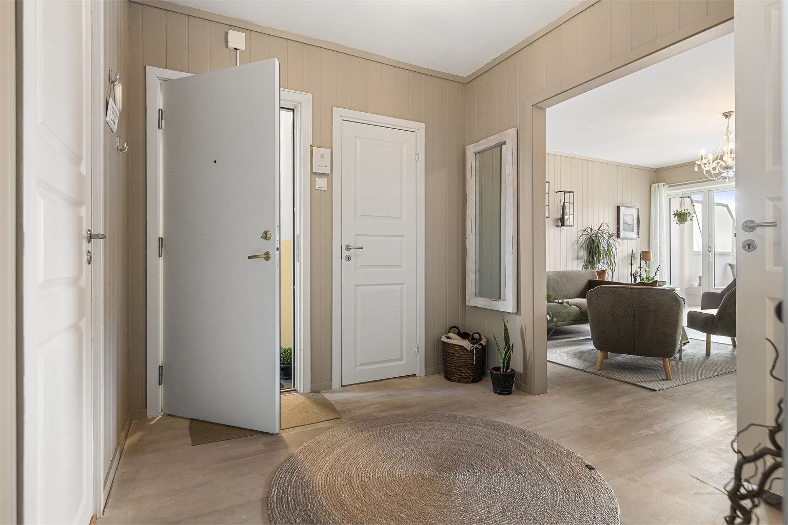 Entréen fungerer som et knutepunkt med adkomst til alle rom, noe som gir en god og praktisk flyt i boligen.