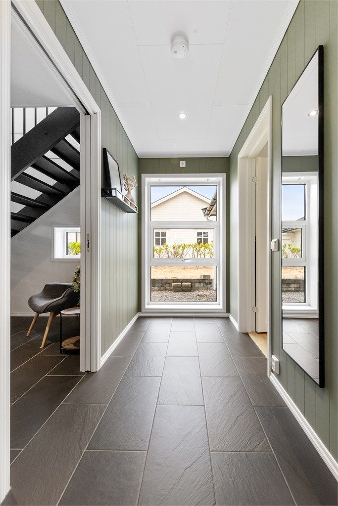 Mellomgang i første etasje, med tilkomst til soverommene og bad. Vindusfeltene sørger for godt med lysinnslipp