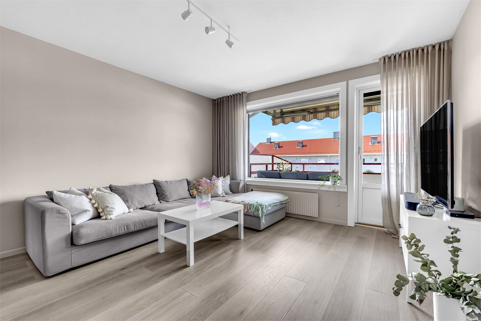 Lys og innbydende stue med store vindusflater som slipper inn rikelig med lys! Det er montert plissègardiner fra Kjells markiser for solskjerming og innsyn. 