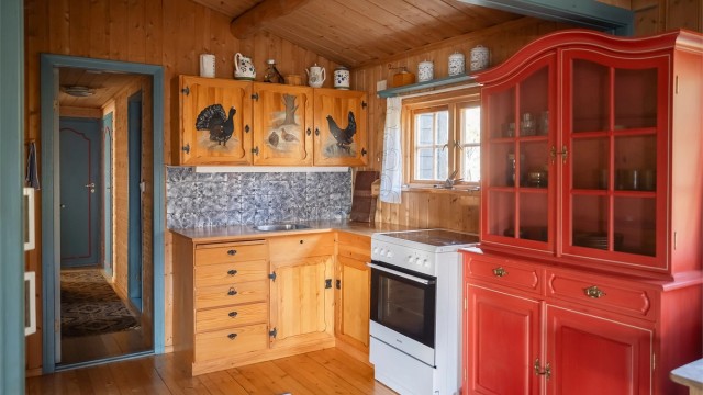 Kjøkkenet ligger naturlig tilbaketrukket fra stuen og har heltre innredning, frittstående komfyr og kjøleskap med fryser.