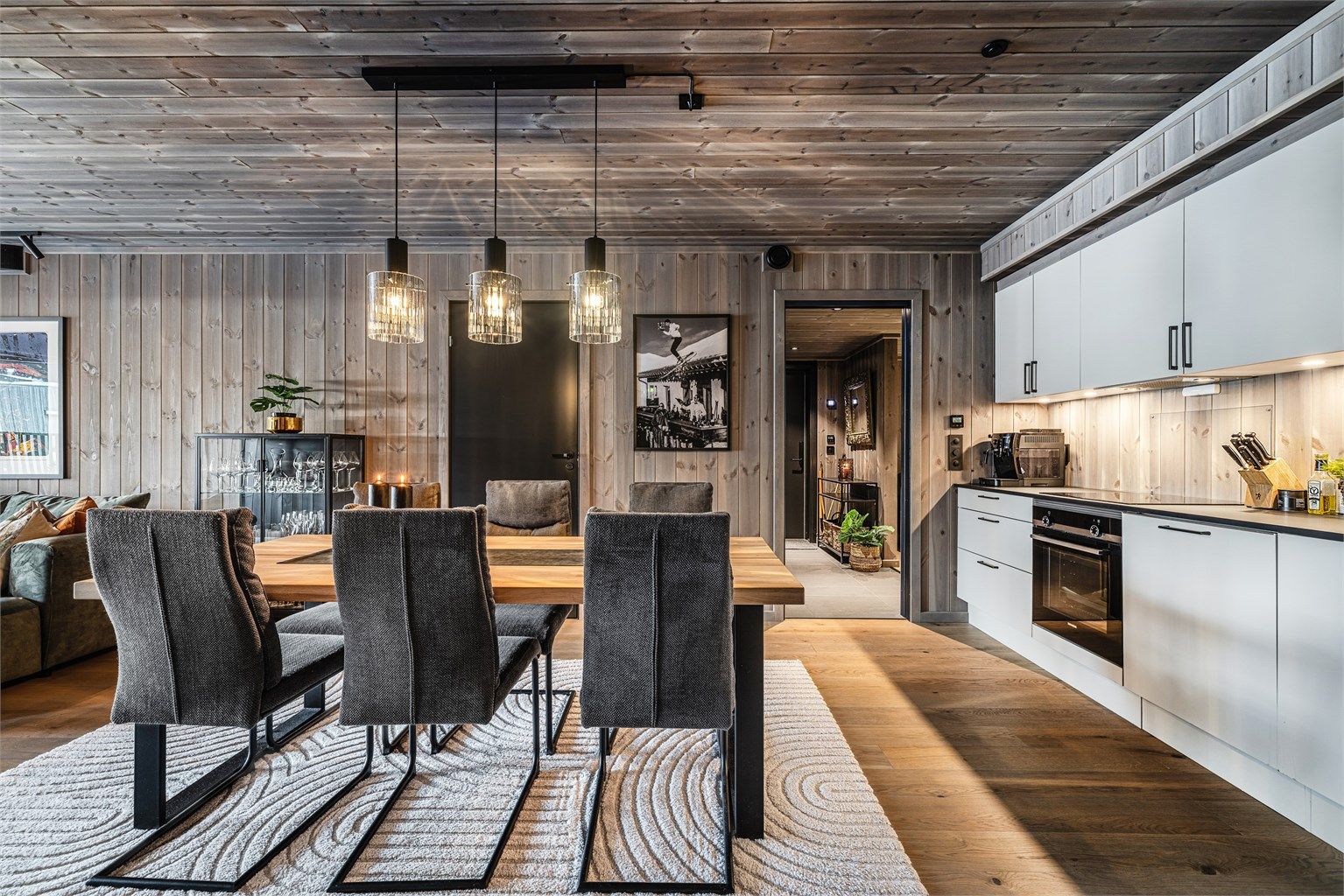 Gjennomgående en-stavs parkett og panelte flater i tak og på vegger skaper en lun og helhetlig atmosfære. 
Foto: Aurelijus Norvaisas