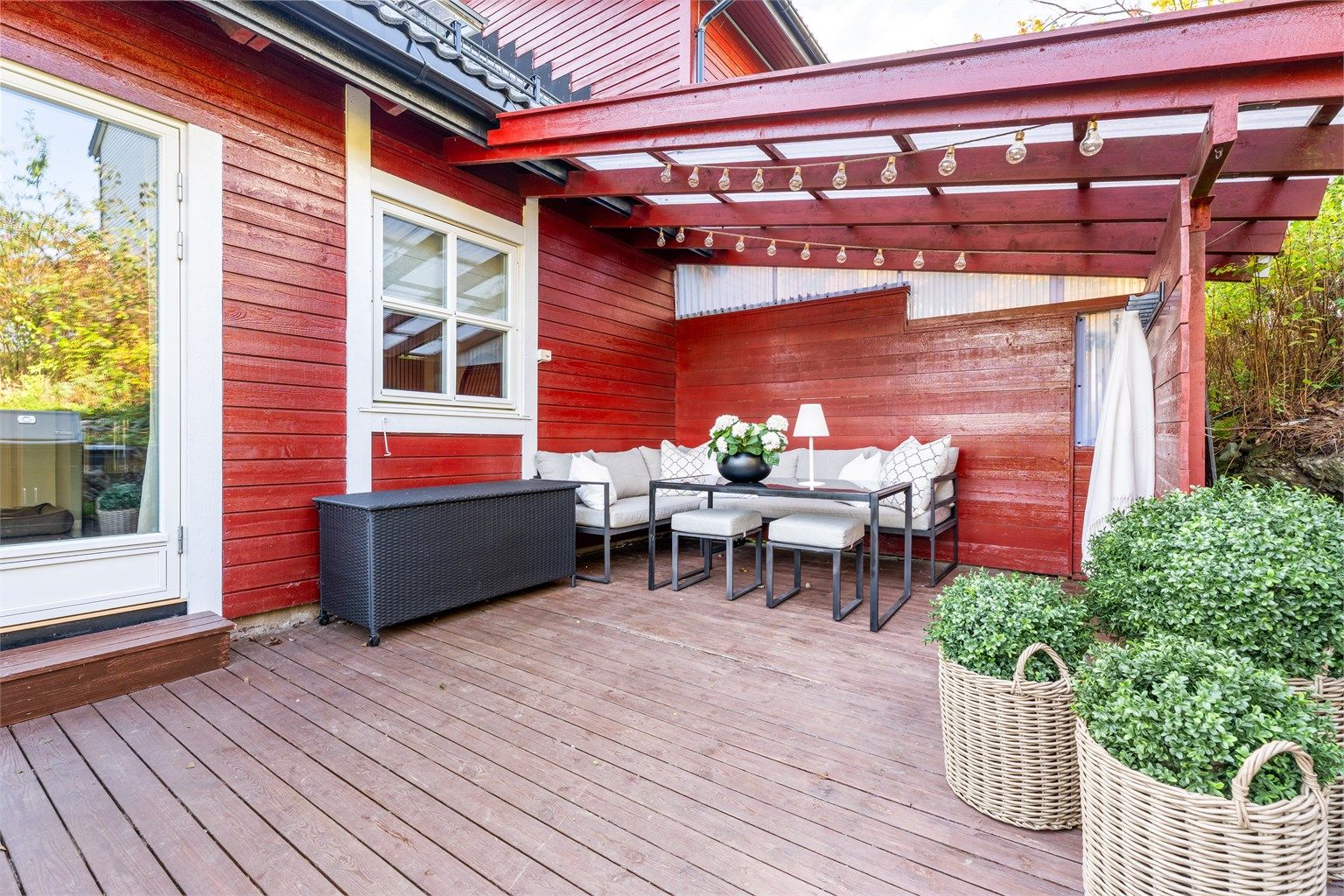 Nordvendt markterrasse med delvis overbygg og skillevegger i treverk.