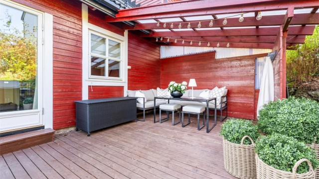 Nordvendt markterrasse med delvis overbygg og skillevegger i treverk.