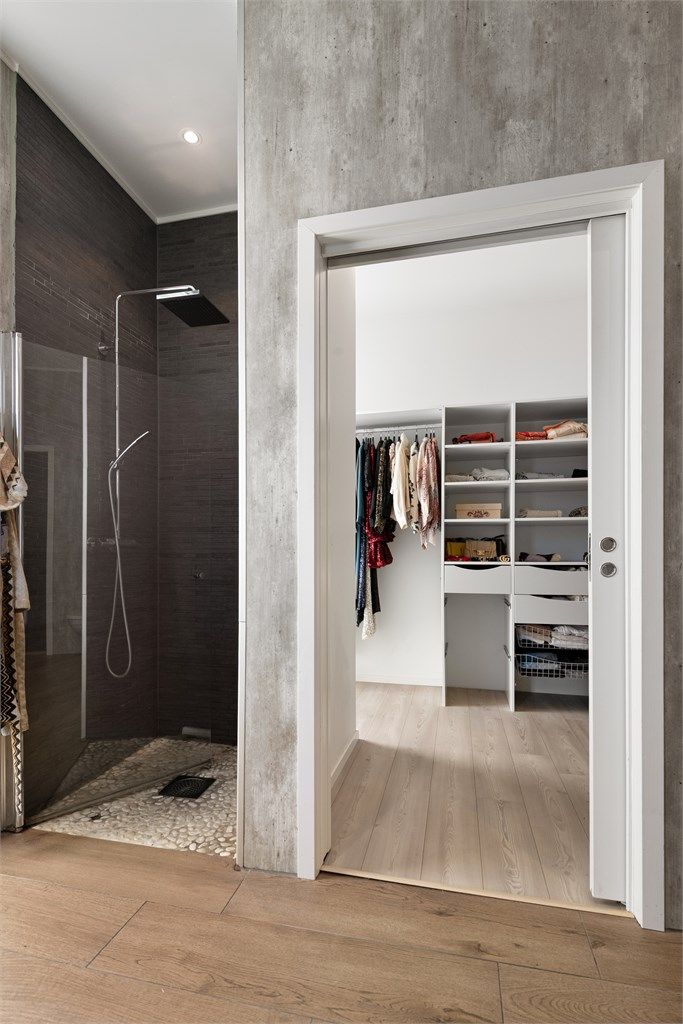 Praktisk gjennomgang med skyvedør mellom walk-in closet og badet.