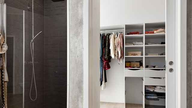 Praktisk gjennomgang med skyvedør mellom walk-in closet og badet.