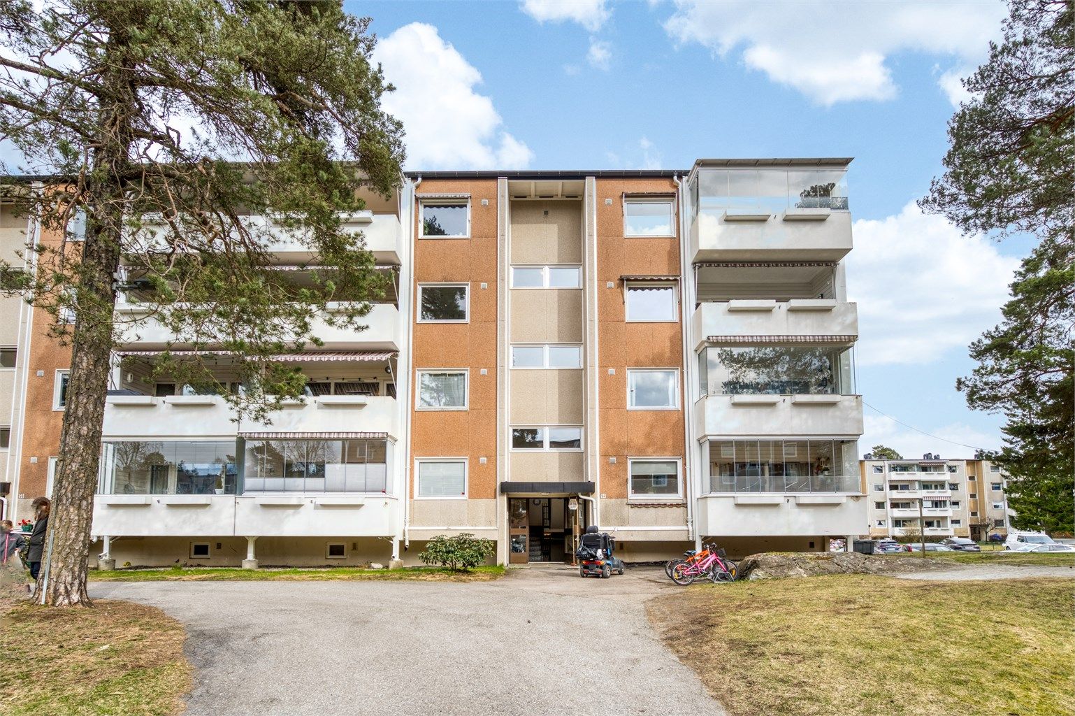 Fasader av murpuss og fasadeplater. Borettslaget har fellesarealer med sittegrupper og lekeplass.