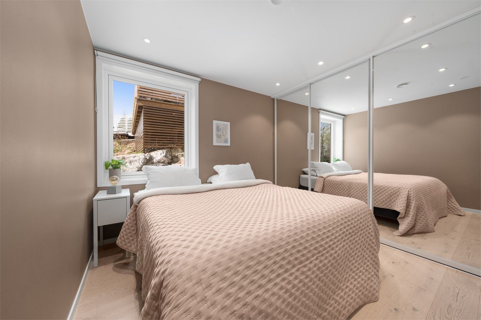 Hovedsoverommet har god plass til dobbeltseng og en stor skyvedørsgarderobe med speilfronter.