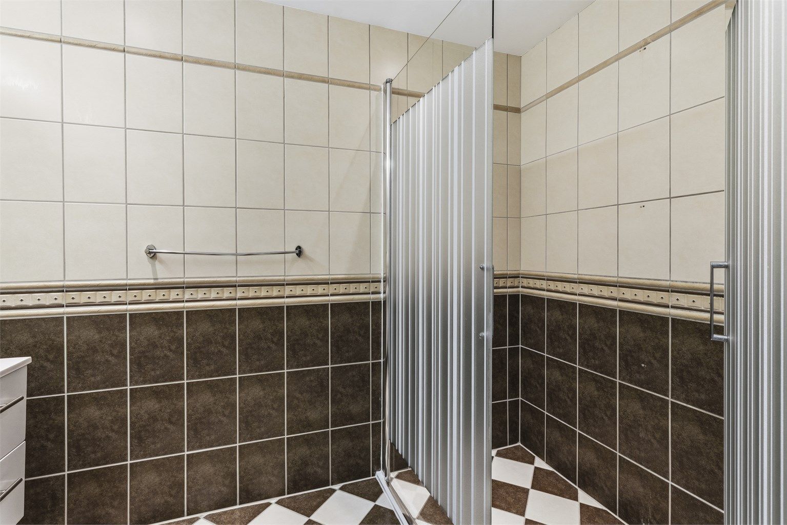 Badet har vegghengt servantinnredning, dobbel ovenpåliggende servant med armaturer, speil med overlys, stikkontakt over servant, dusjnisje med glassvegg og glassdør, samt vegghengt dusjarmatur (hånddusj og regndusj)