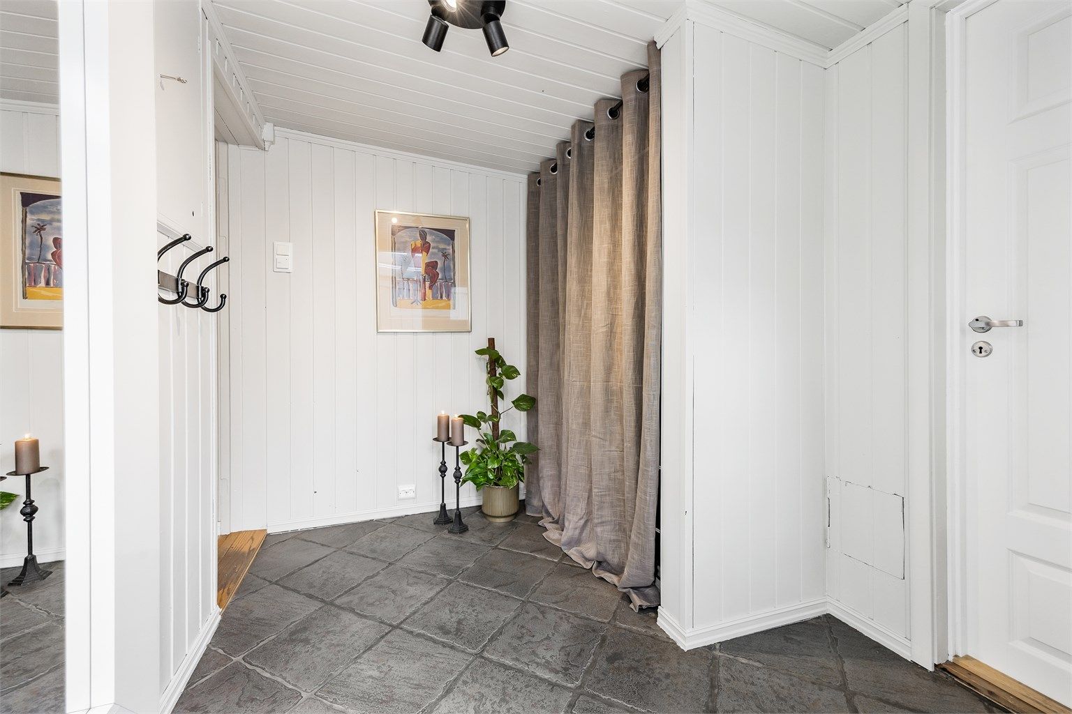 Entréen har flislagt gulv med gulvvarme og god plass til å henge fra seg yttertøy.