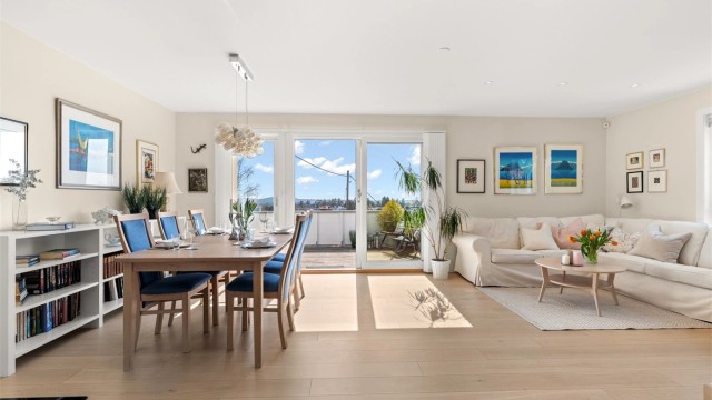 Stue, spisestue og kjøkken i delvis åpen løsning som skaper en stor, lys og sosial sone.