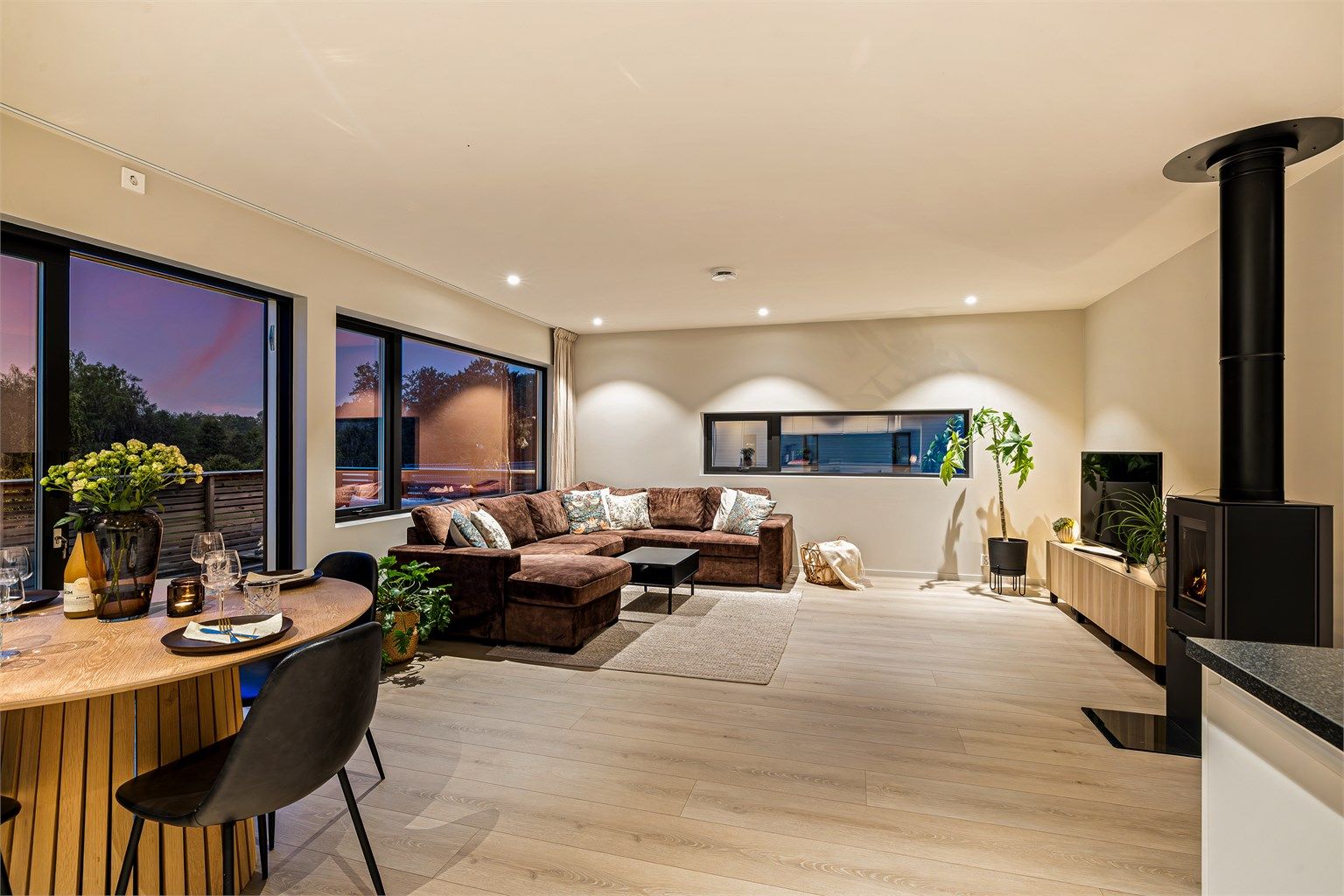 Stor stue med flere store vindusflater som slipper både lyset og naturen rett inn i stua