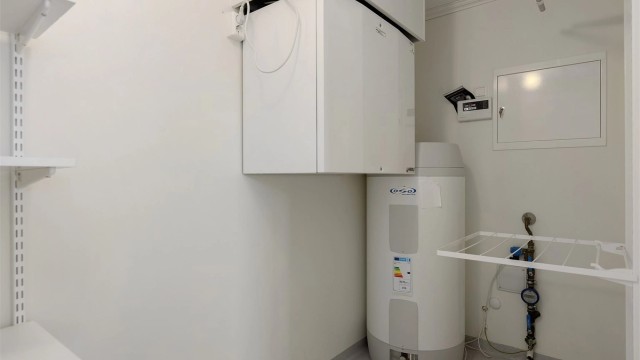 Innvendig bod med varmtvannsbereder og aggregat for balansert ventilasjon.
