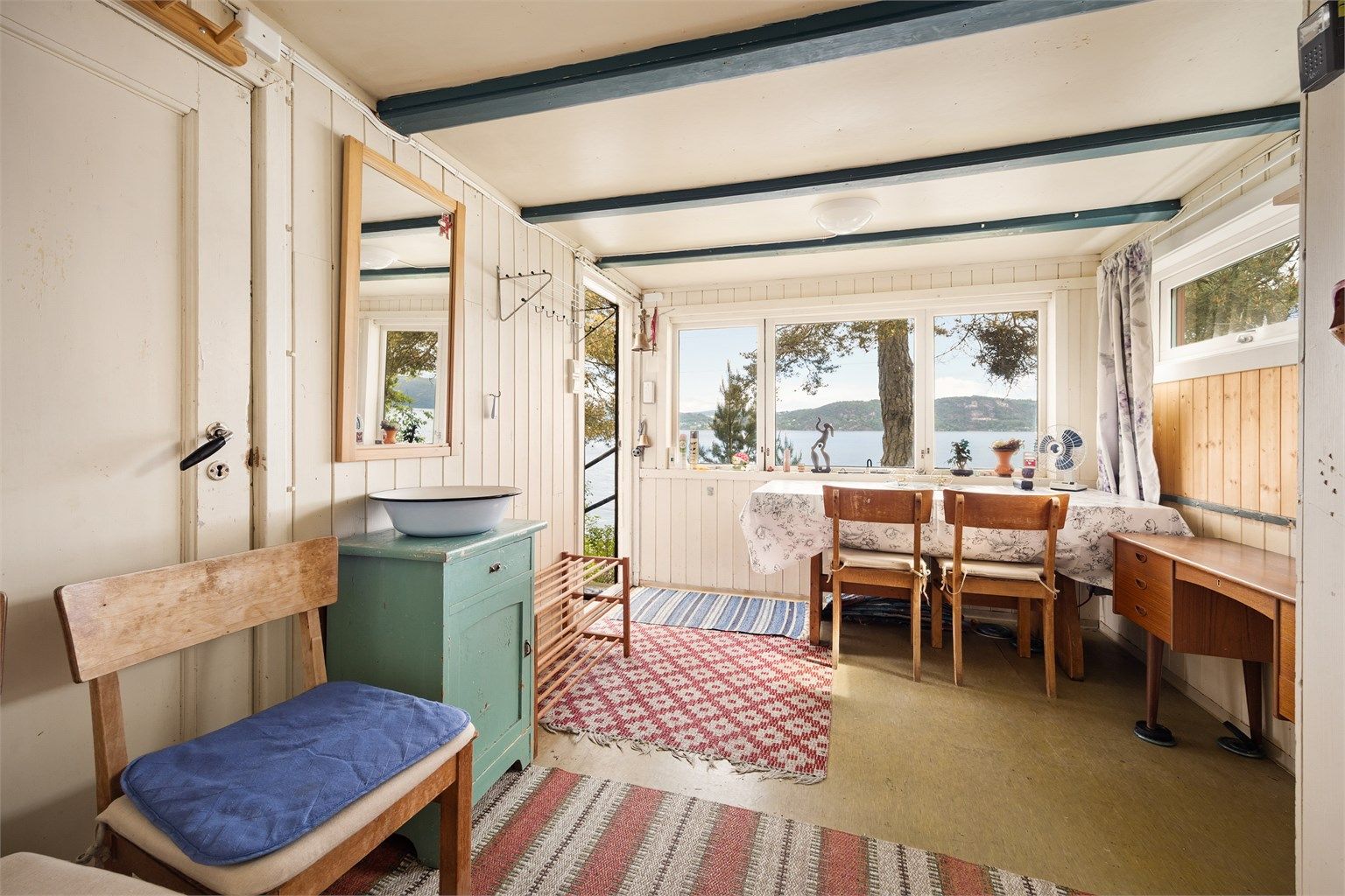 Adkomst inn i hytta i et lyst rom som fungerer som både entré og spisestue. Her er det naturlig plass til å henge fra seg yttertøy, videre er det plass til spisebord. 