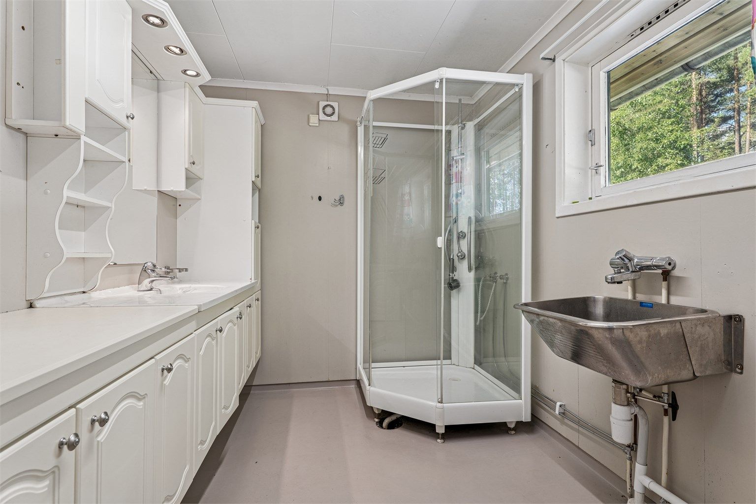 Bad med gulvvarme, dusjkabinett, servantinnredning, utslagsvask og opplegg for vaskemaskin.