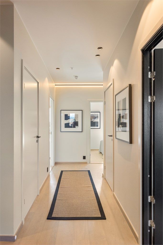 Innfelt lyslist og downlights gir en lun og jevn belysning i gangen.
