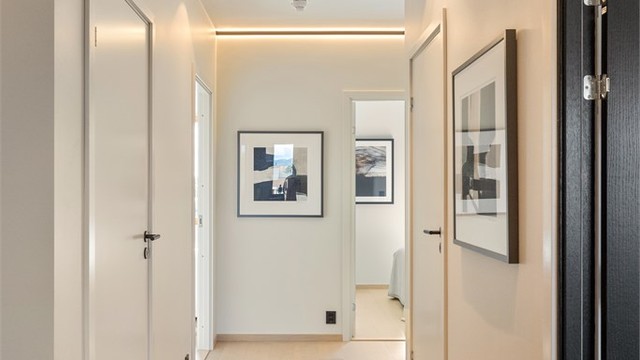 Innfelt lyslist og downlights gir en lun og jevn belysning i gangen.