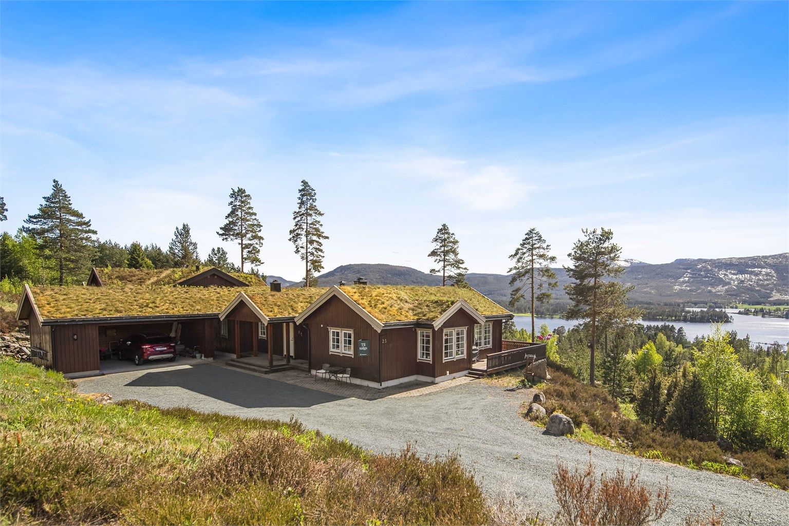 Stor gårdsplass og carport med bod