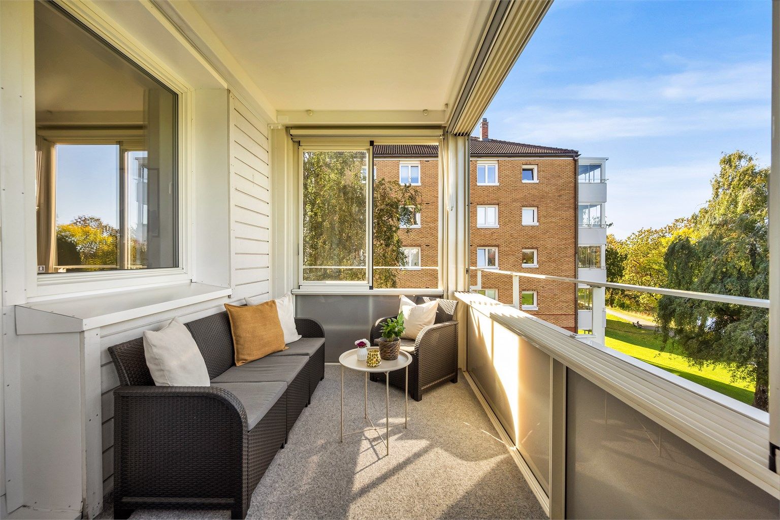 Balkongen har god plass til både sofa og loungemøbler, og er et deilig sted å trekke seg tilbake med en god bok og utsikt mot trærne.