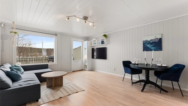 Rommet har en åpen og luftig atmosfære med gjennomgående tregulv.