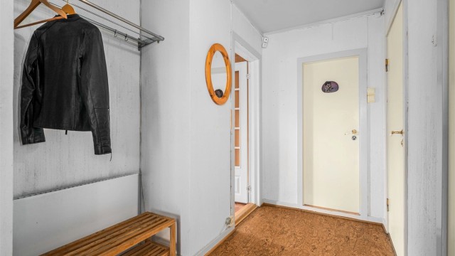 Gangen binder sammen rommene i første etasje og har vinylbelegg på gulvet.