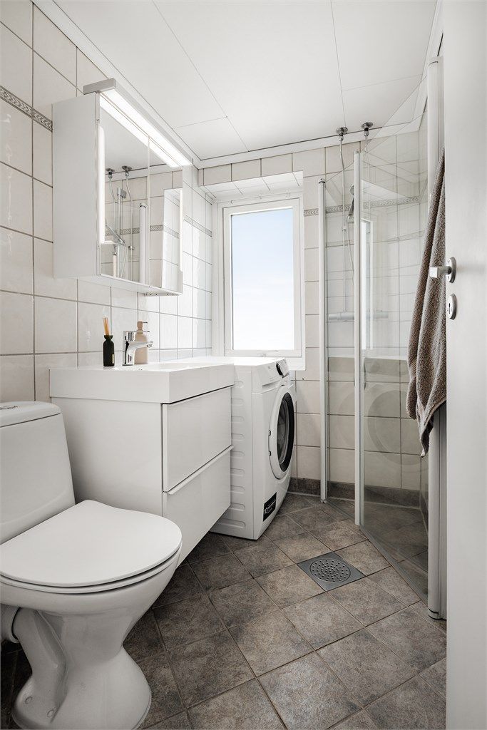 Vegghengt servantinnredning, gulvstående toalett, dusjhørne og opplegg for vaskemaskin.