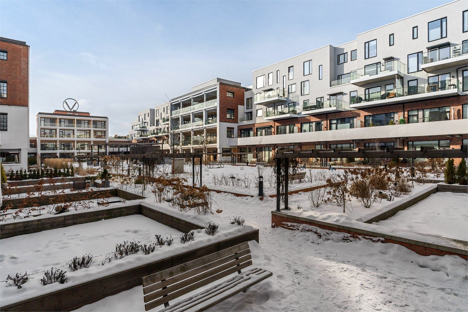 Felles bakgård, opparbeidet med plen, beplantninger, sosiale soner og lekeområder.