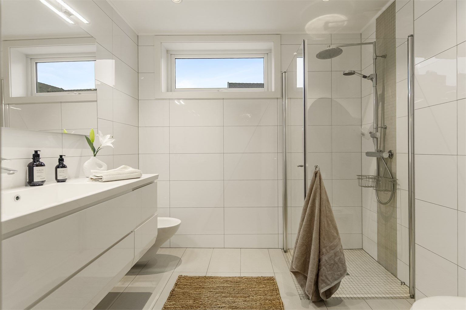 Lekkert bad i tidløse flisevalg og med vannbåren varme i gulv