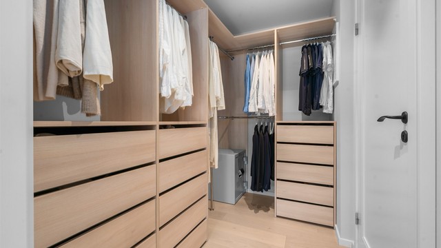 Praktisk walk-in closet med rikelig med skap- og hylleplass.