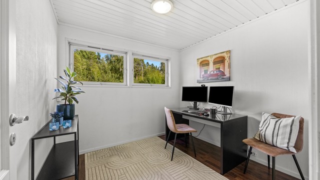 Kontor med god plass til arbeidsplass, og vindu mot grønne omgivelser som slipper inn fint dagslys.