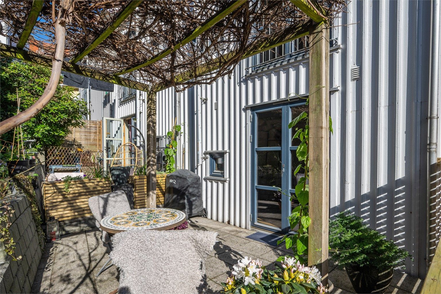 Et innholdsrikt rekkehus over tre plan, med to private uteplasser. Her er den skjermede markterrassen med adkomst fra første etasje.