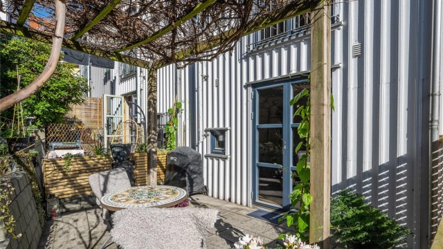 Et innholdsrikt rekkehus over tre plan, med to private uteplasser. Her er den skjermede markterrassen med adkomst fra første etasje.